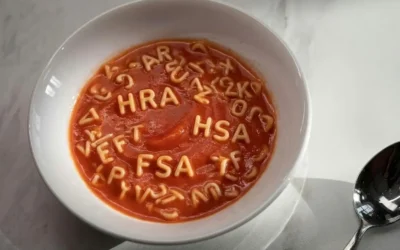 White bowl filled with tomato alphabet soup clearly spelling out the health benefit acronyms HRA, HSA, and FSA.